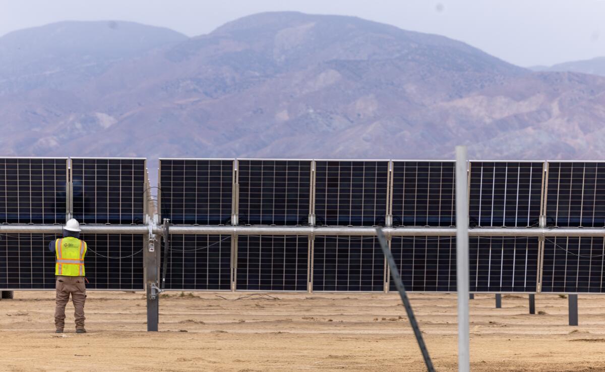 A worker installs photovoltaic panels at the Eland solar and storage project in California's Kern County on Nov. 25.