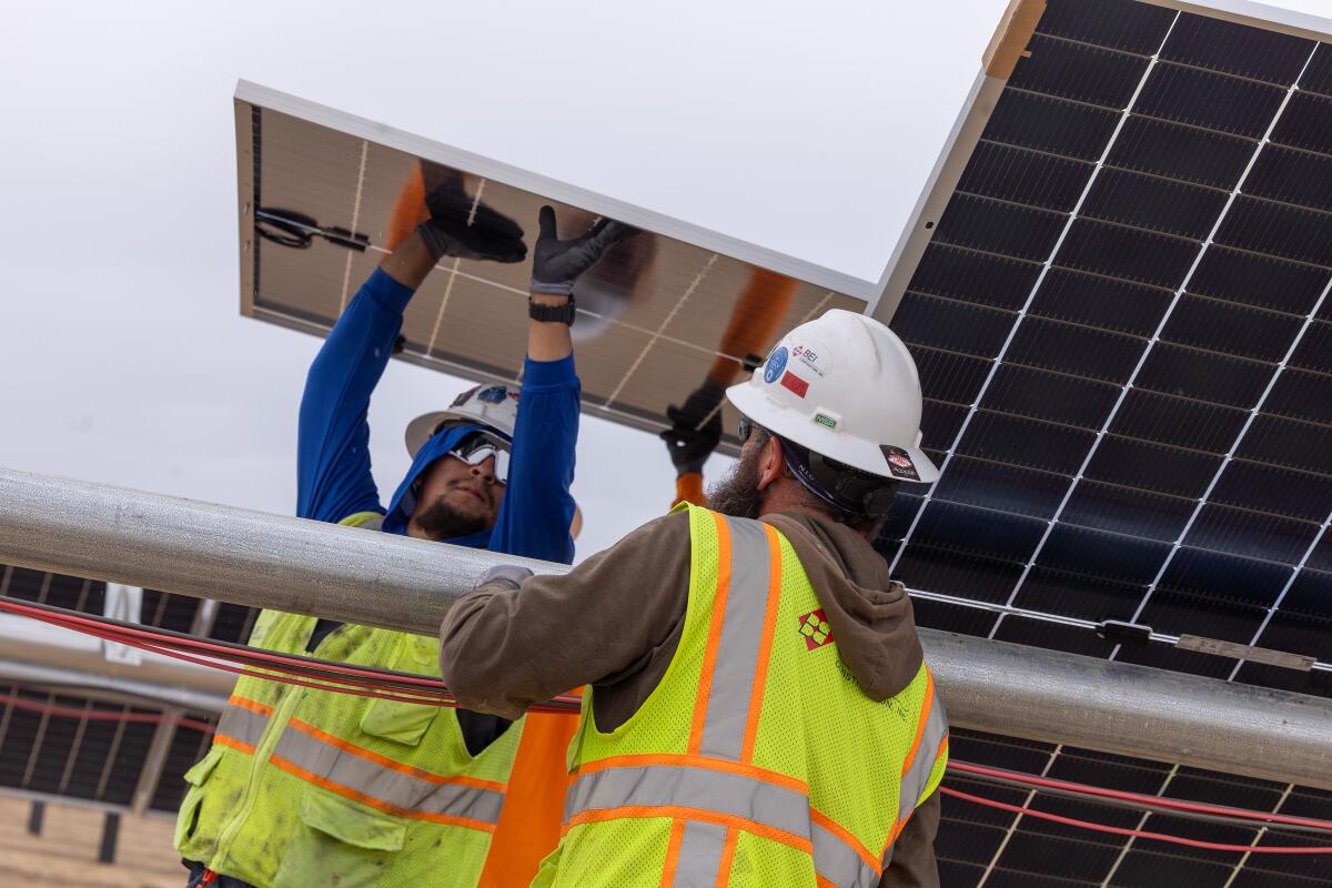 Workers install photovoltaic panels at the Eland solar and storage project on Nov. 25.