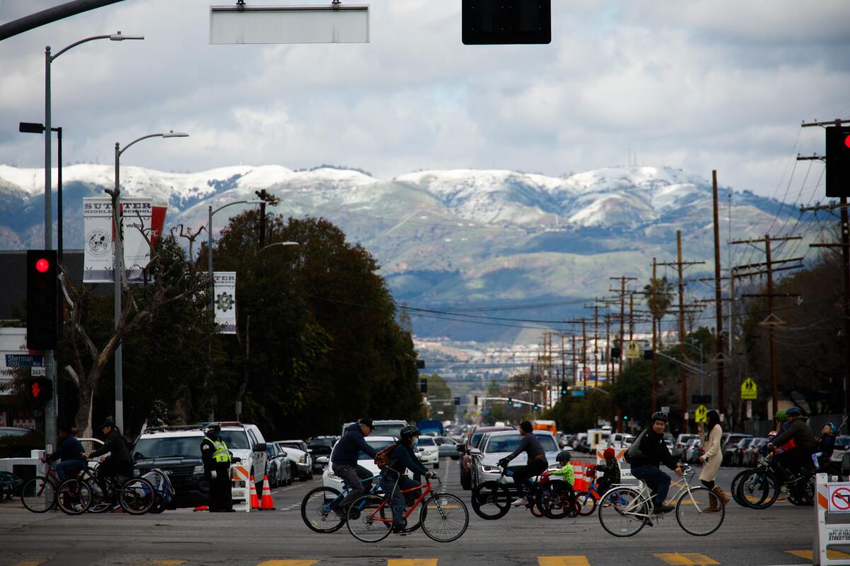 Visitors walk and bike at a recent CicLAvia in the San Fernando Valley. Mountains can be seen in the distance.