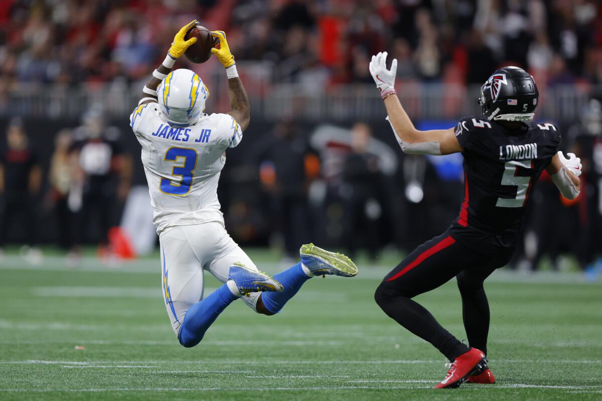 Chargers safety Derwin James Jr. (3) intercepts this pass intended for Falcons receiver Drake London (5).