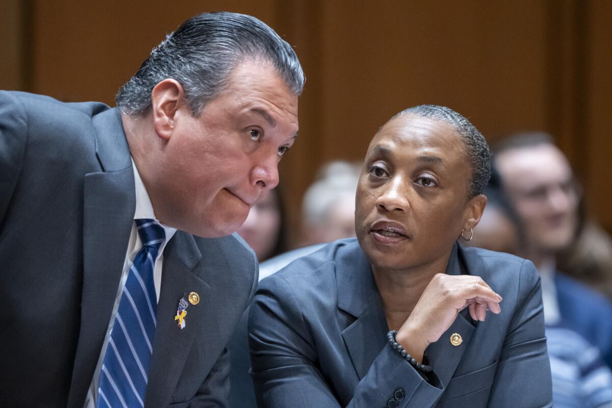 Alex Padilla leaning toward Laphonza Butler as she speaks with him during a meeting.