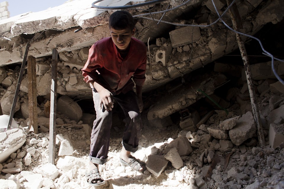 A Syrian youth walks over the rubble of a destroyed house in Al-Bab in the northern province of Aleppo in 2012