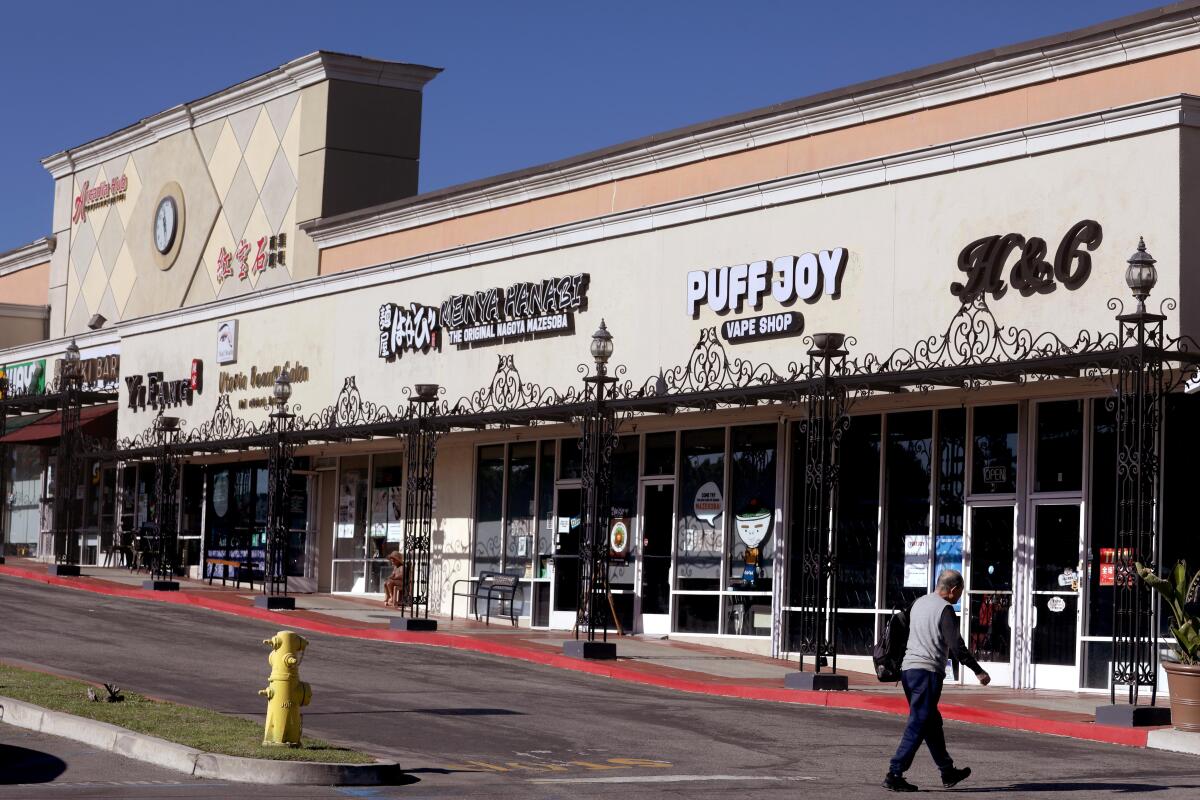 A pedestrian walks towards the Arcadia Hub Shopping Center in Arcadia.