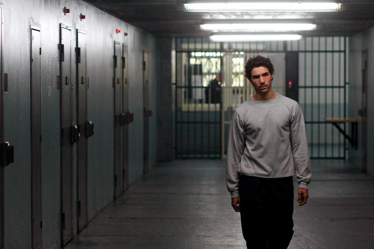 A man walks down a prison hallway.