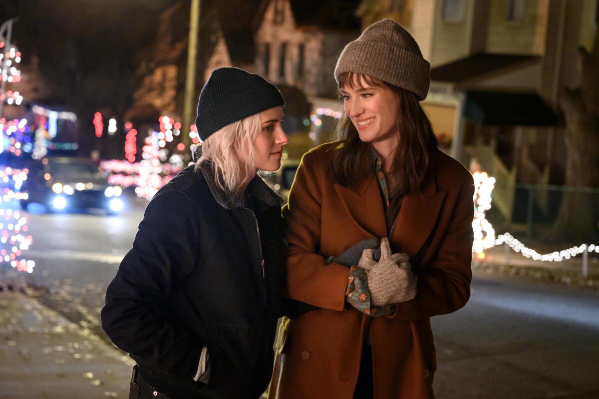 Two women walk in winter hats.