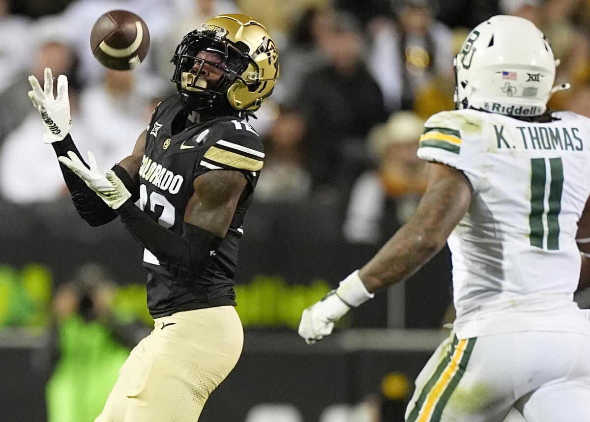 Colorado wide receiver Travis Hunter, left, pulls in a pass ahead of Baylor linebacker Keaton Thomas.