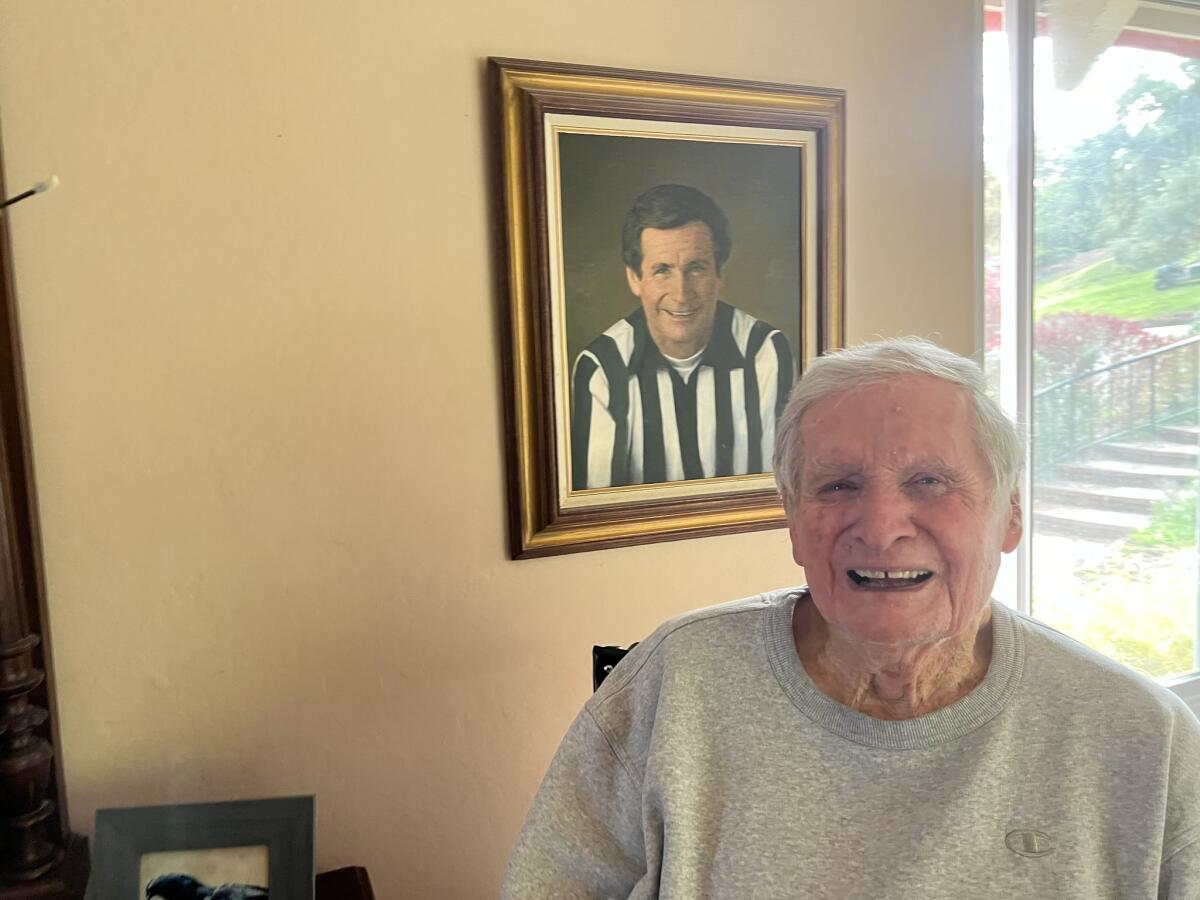 Former NFL referee Jim Tunney sits in front of a portrait of himself at his home in Pebble Beach, Calif.