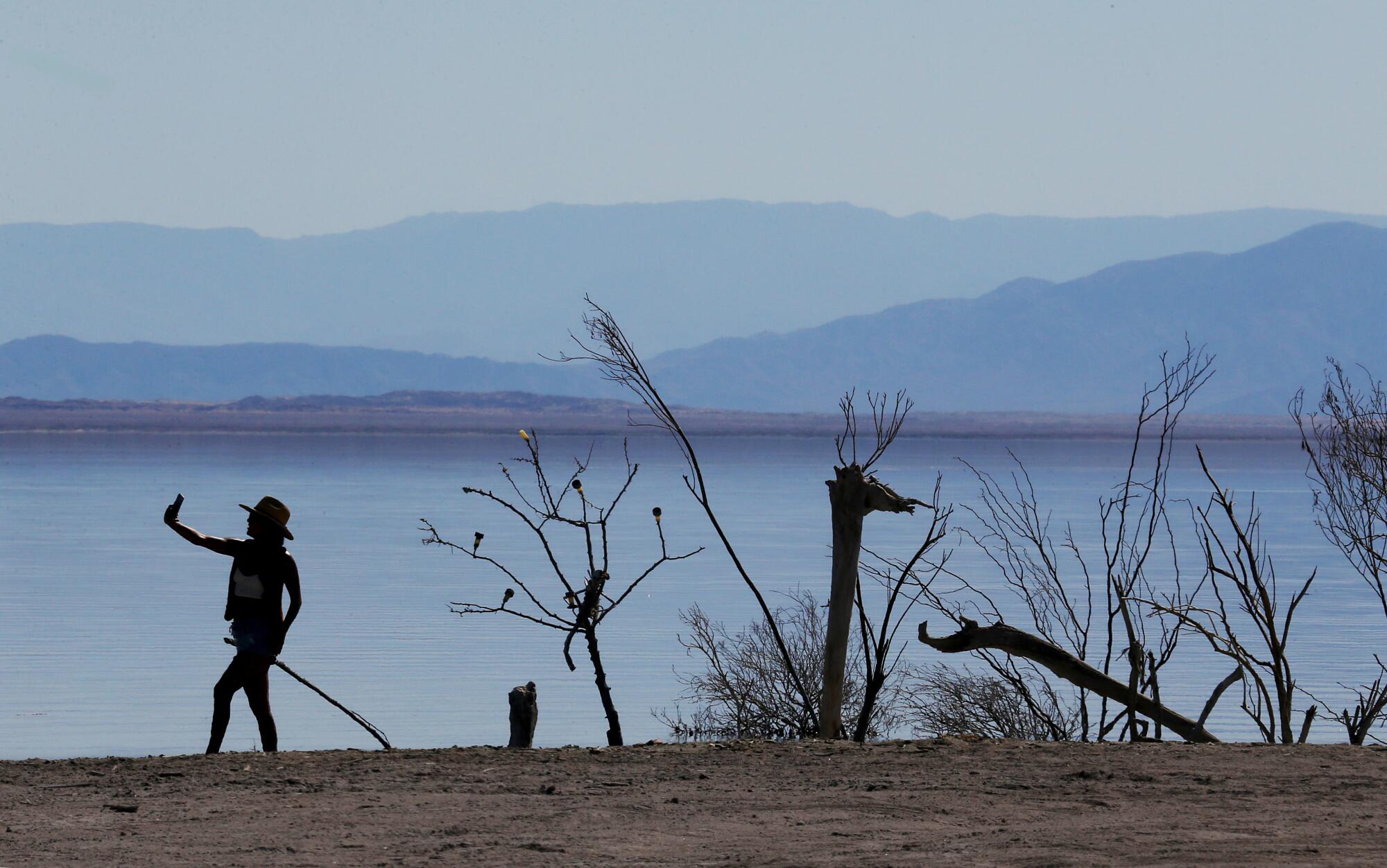 A visitor takes a selfie with public art in Bombay Beach, a tiny community on the Salton Sea.