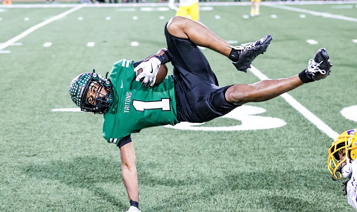 Isaiah Dillon of Oxnard Pacifica is airborne catching a pass against Sacramento Grant.