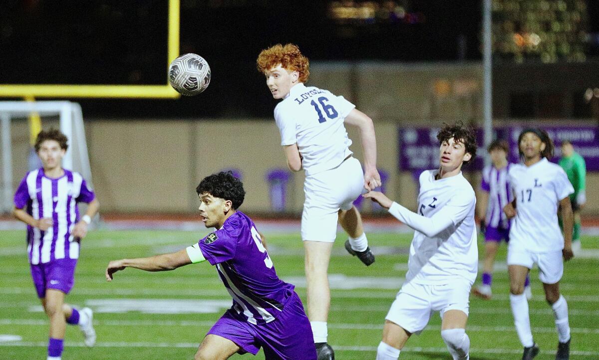 Loyola midfielder Tucker Adams heads the ball to a teammate during the Cubs' 2-0 win Tuesday at Cathedral.