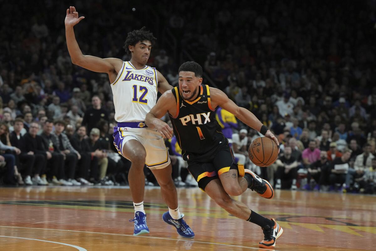 Lakers guard Max Christie, left, tries to cut off a drive by Suns guard Devin Booker during a game last month.