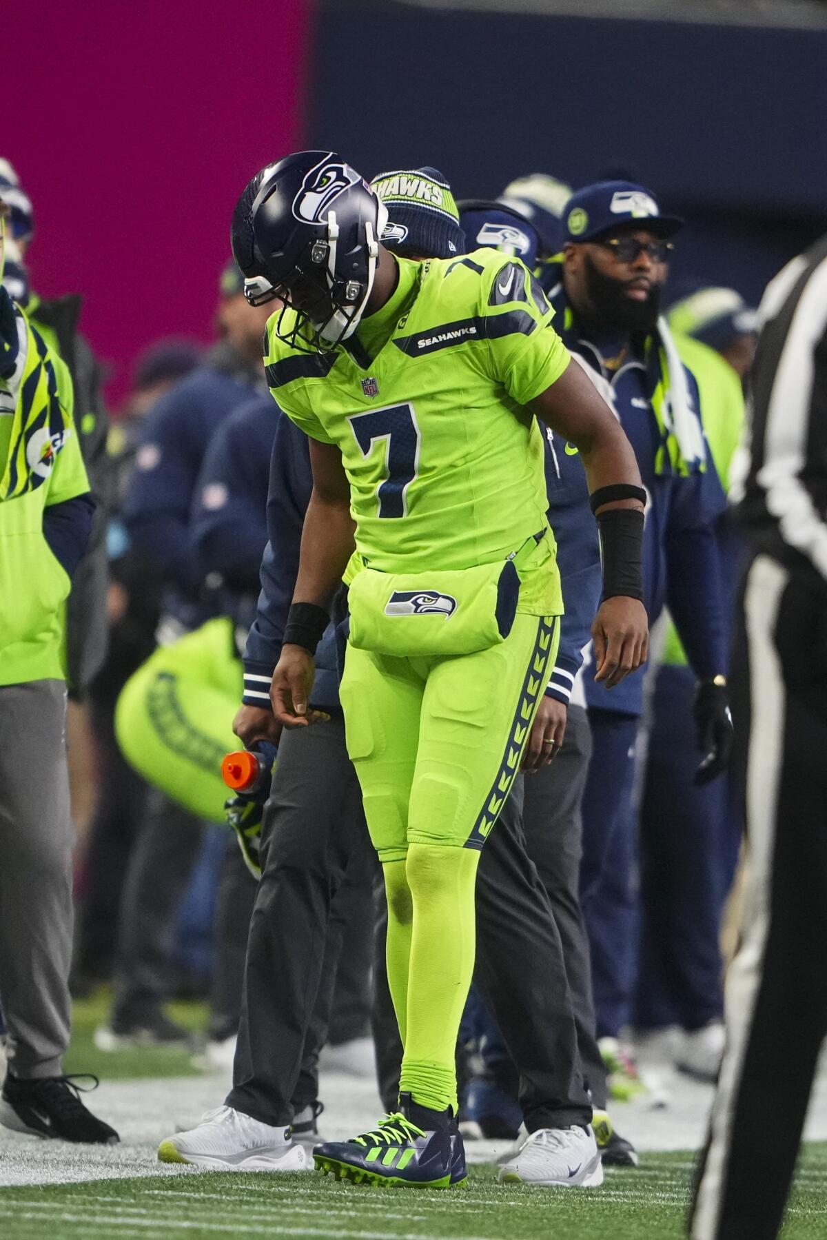 Seahawks' Geno Smith limps off the field after hurting his knee during a loss to the Packers. 