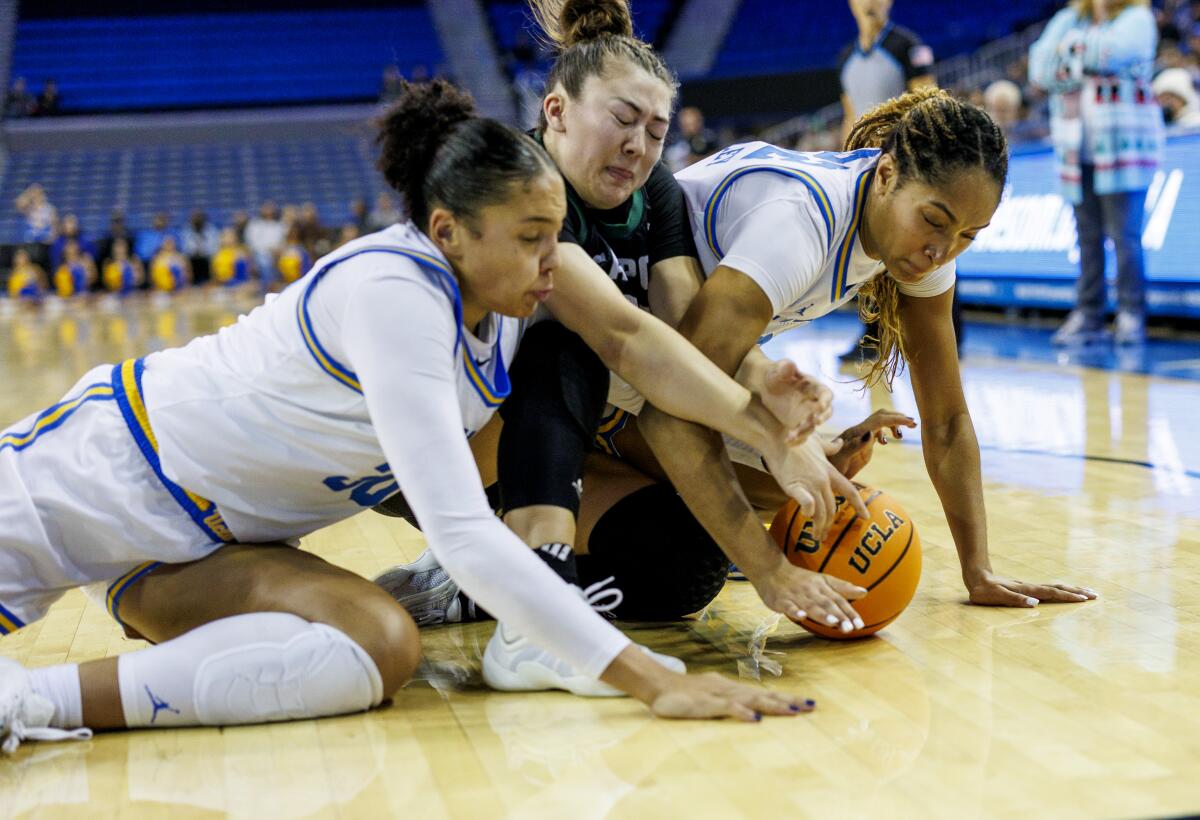 UCLA's Timea Gardiner, left, and Kendall Dudley squeeze out Cal Poly guard Ashley Hiraki for a loose ball Monday.