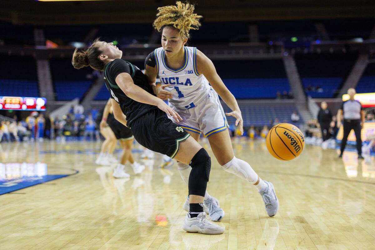 UCLA guard Kiki Rice, right, is called for an offensive foul on Cal Poly Mustangs guard Ashley Hiraki.