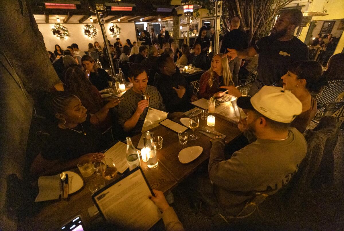 Strangers interact as they dine together at Bacari in Los Angeles 