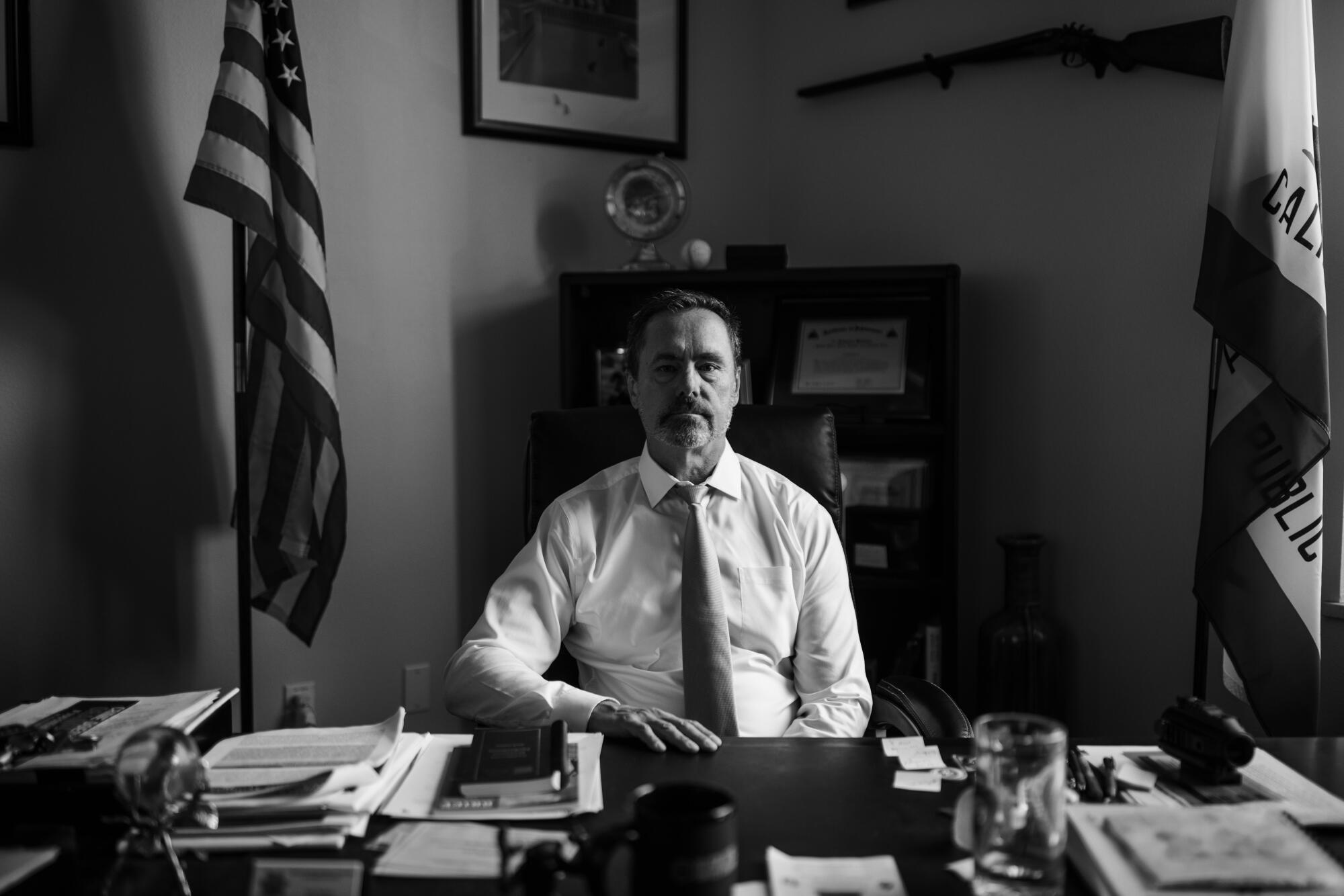 El Dorado County Dist. Atty. Vern Pierson sits at his desk, an American flag behind him.