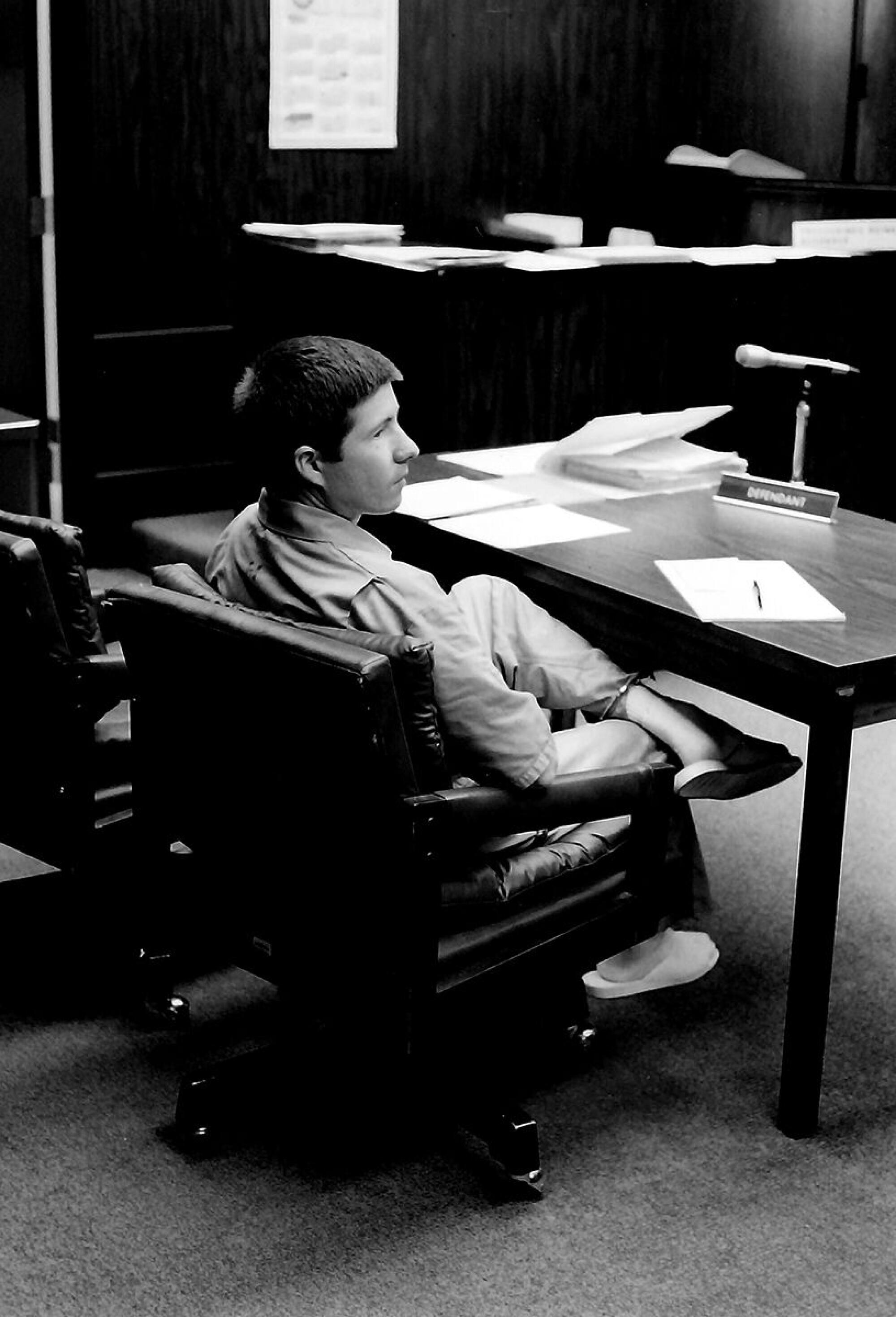 Michael Anthony Cox sits alone at a courtroom table.