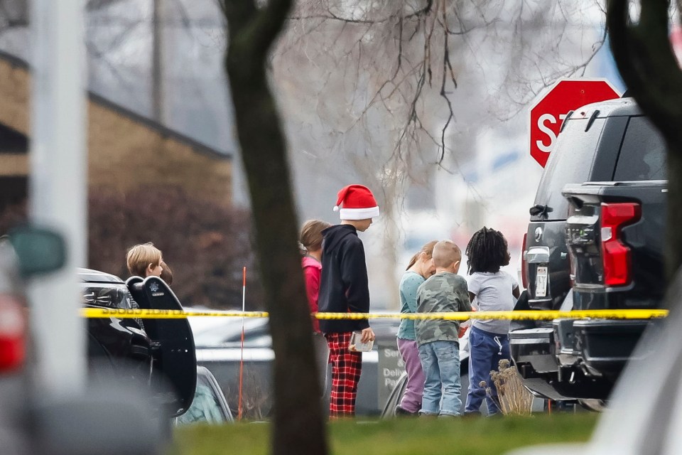 School children walking past police tape as they are escorted away from Abundant Life Christian School