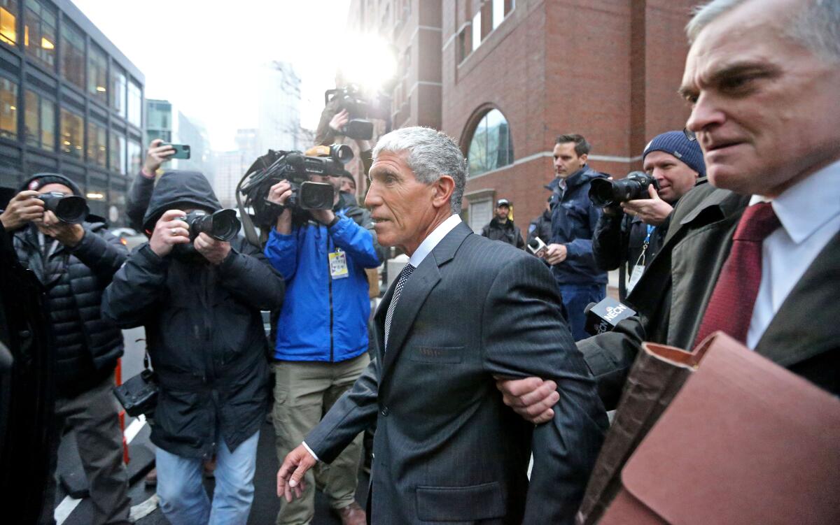 Two men walk by photographers.