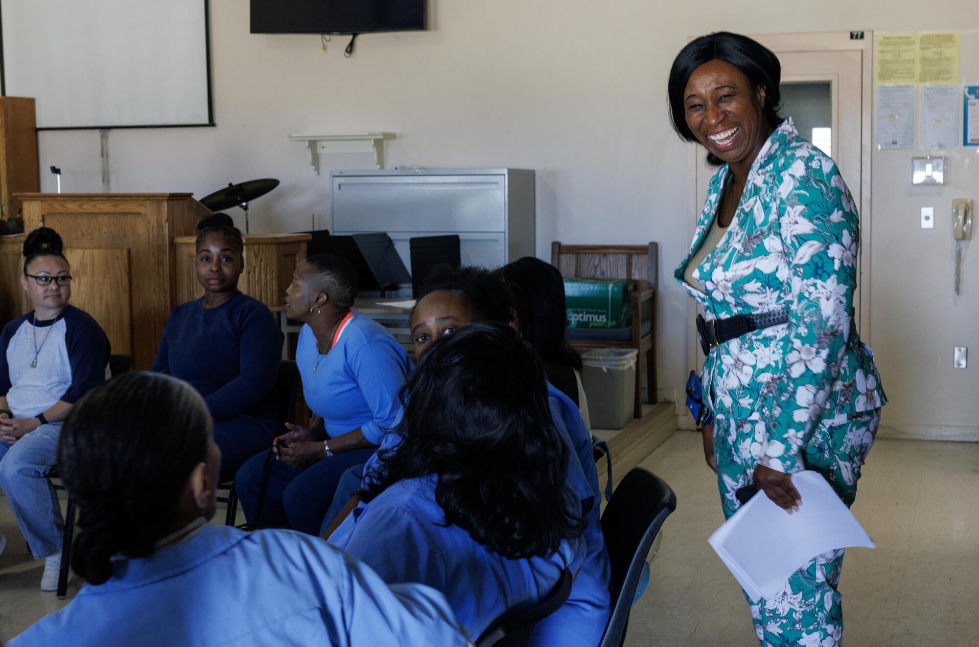 A woman smiles standing behind seated women.