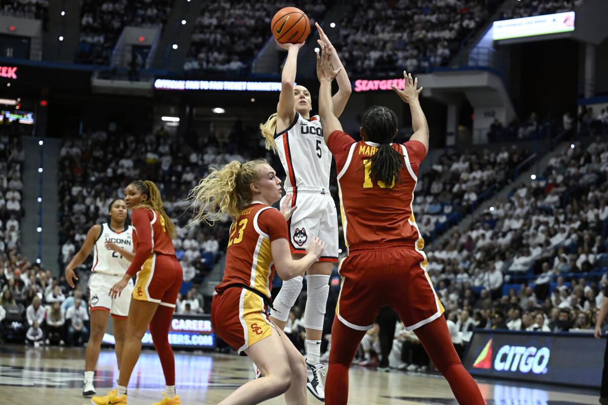 Connecticut guard Paige Bueckers takes a shot in front of USC guard Avery Howell and center Rayah Marshall.