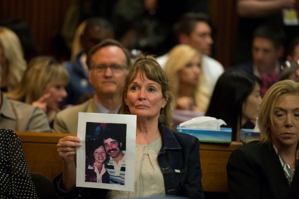 Melanie Barbeaux holds a photo of victims of the Golden State Killer in the courtroom at Joseph James DeAngelo