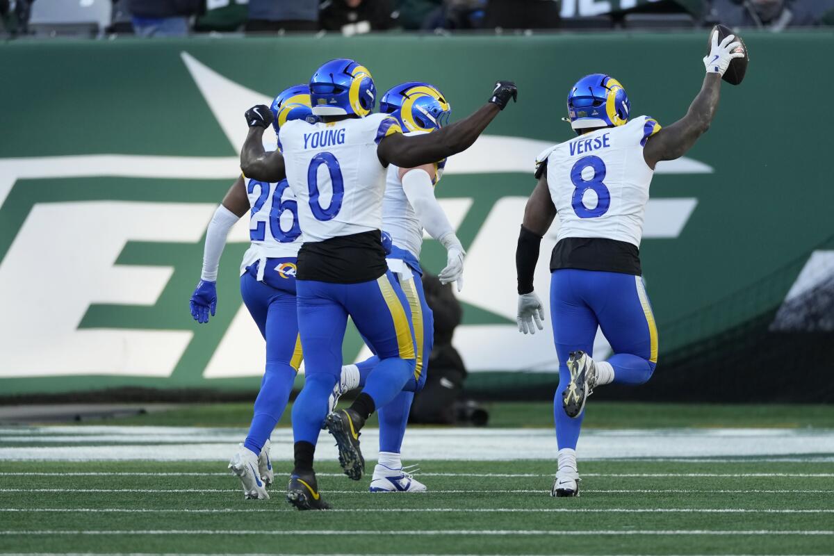 Rams linebacker Jared Verse (8) celebrates his fumble recovery against the Jets with teammates.