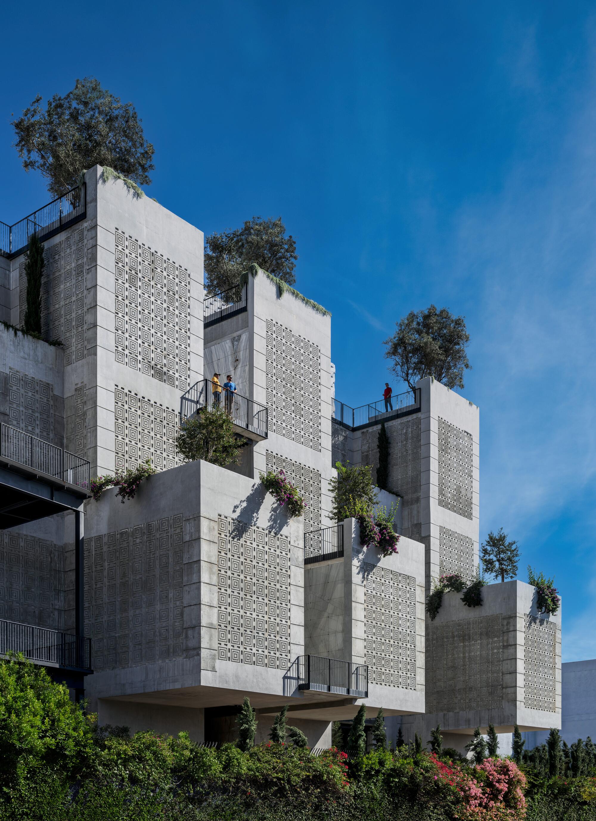 Rectangular masses of patterned concrete jut out toward the sidewalk like hulking floating gardens. 