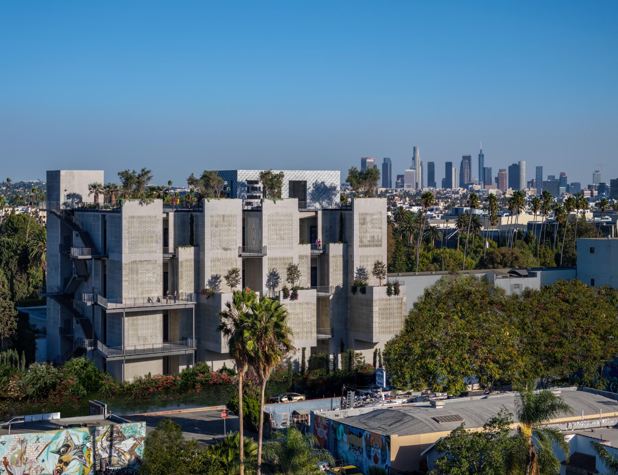 The concrete towers of the new mausoleum rise above L.A.'s cityscape, the skyscrapers of downtown off in the distance. 