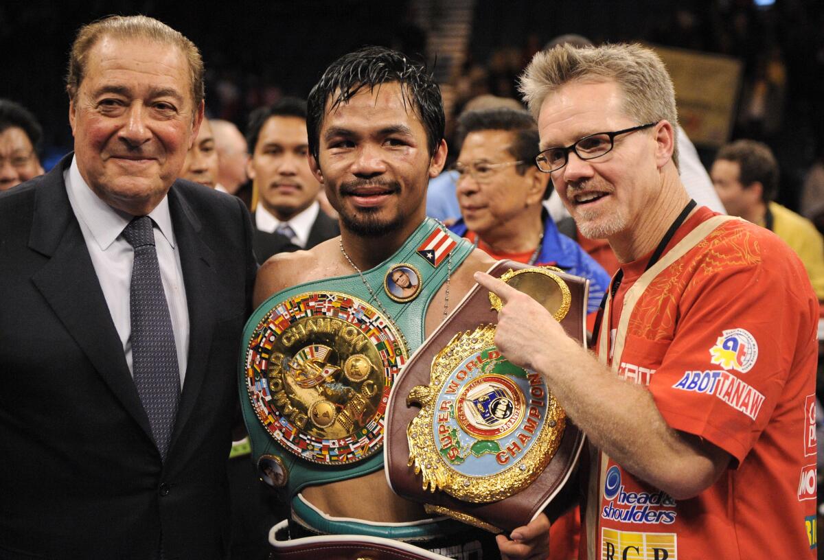 Manny Pacquiao stands between promoter Bob Arum, left, and trainer Freddie Roach after defeating Miguel Cotto in 2009.