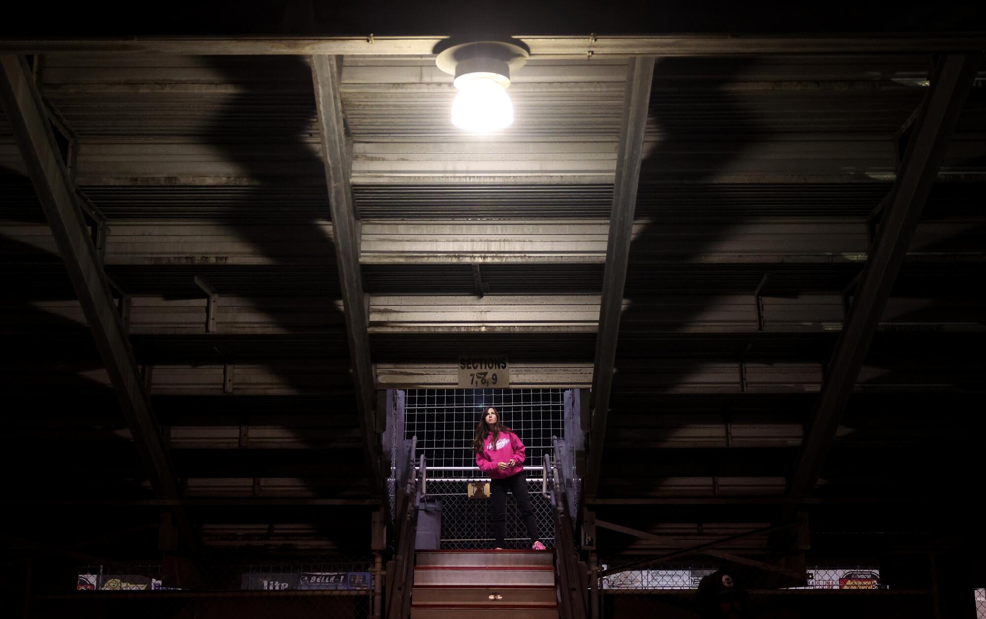 A woman walks under the stands on the final night of racing at Irwindale Speedway.