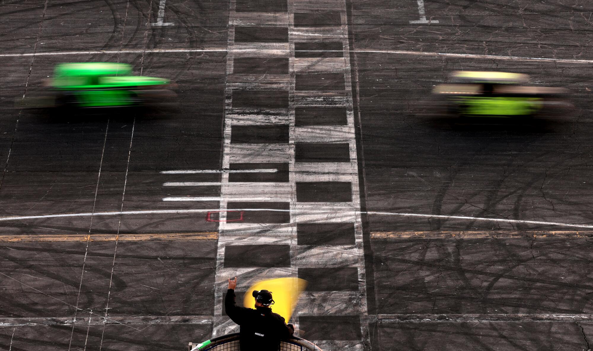 The yellow caution flag is waved during competition on the final day of racing at Irwindale Speedway.