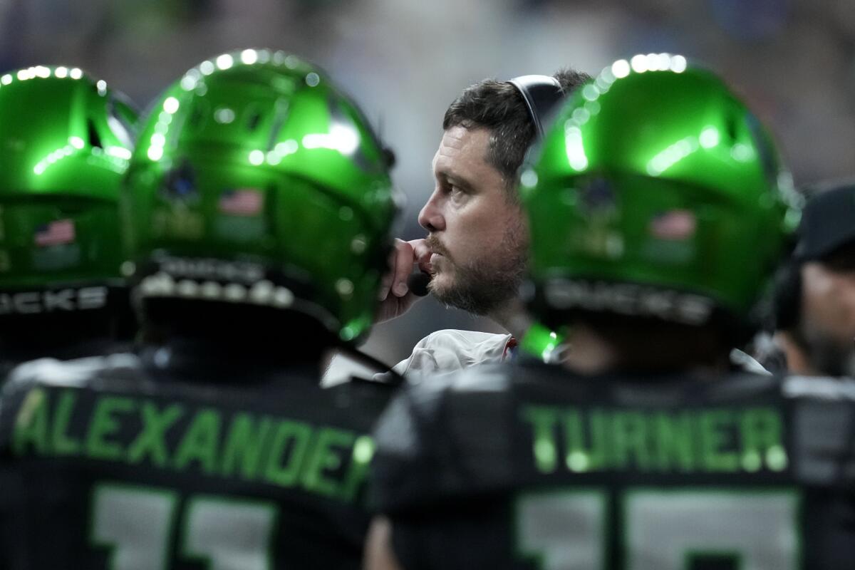 Oregon head coach Dan Lanning, center, talks to his team during the first half.