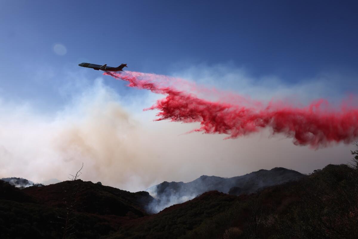 A firefighting jet drops retardant over Malibu Canyon during the Franklin fire