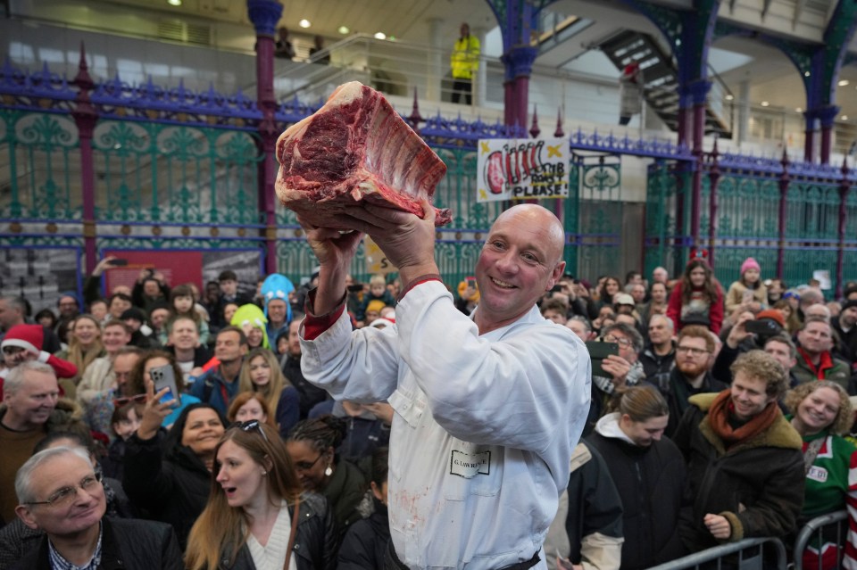 A butcher displays cut of meat for sale to customers