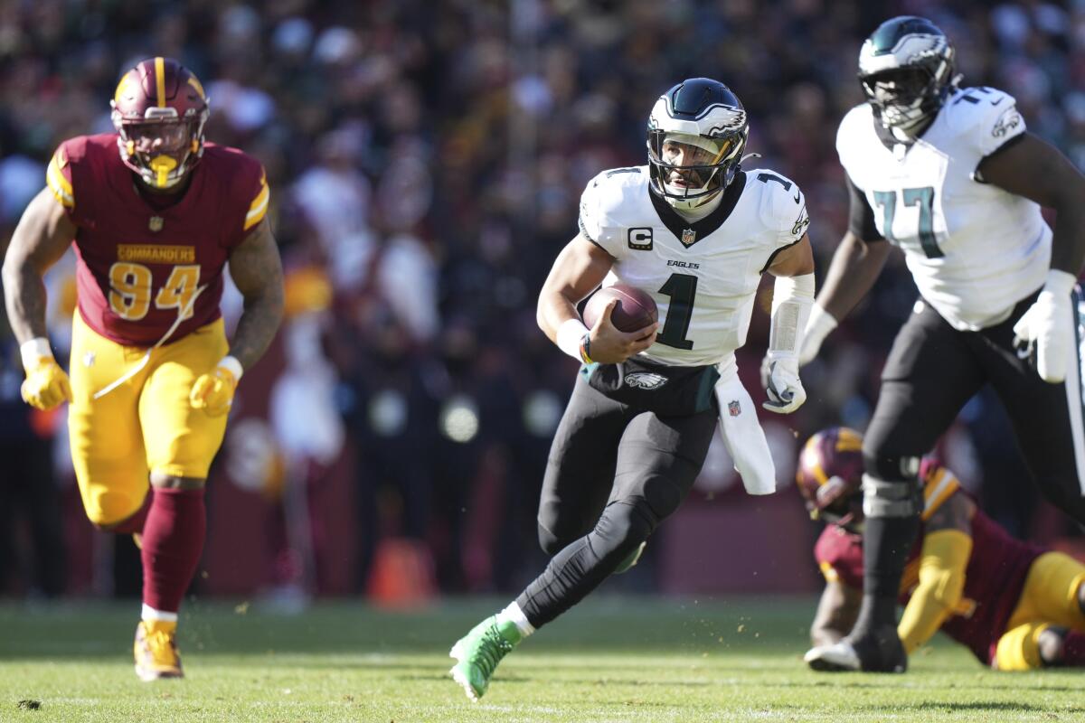 Eagles quarterback Jalen Hurts (1) escapes the pocket and runs against the Commanders in Week 16.