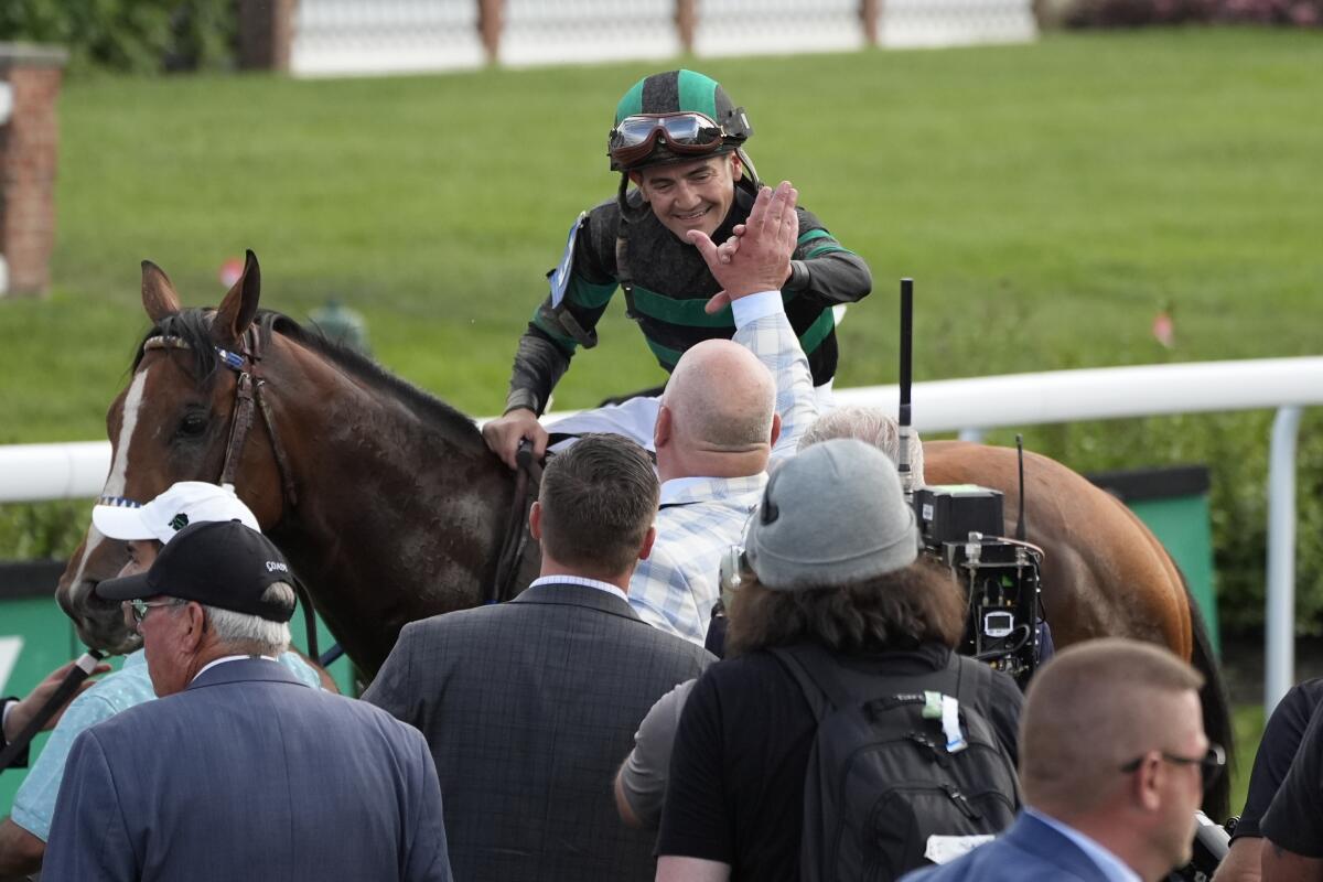 Jockey Brian Hernandez Jr. high-fives trainer Kenny McPeek while aboard Mystik Dan after winning the Kentucky Derby.