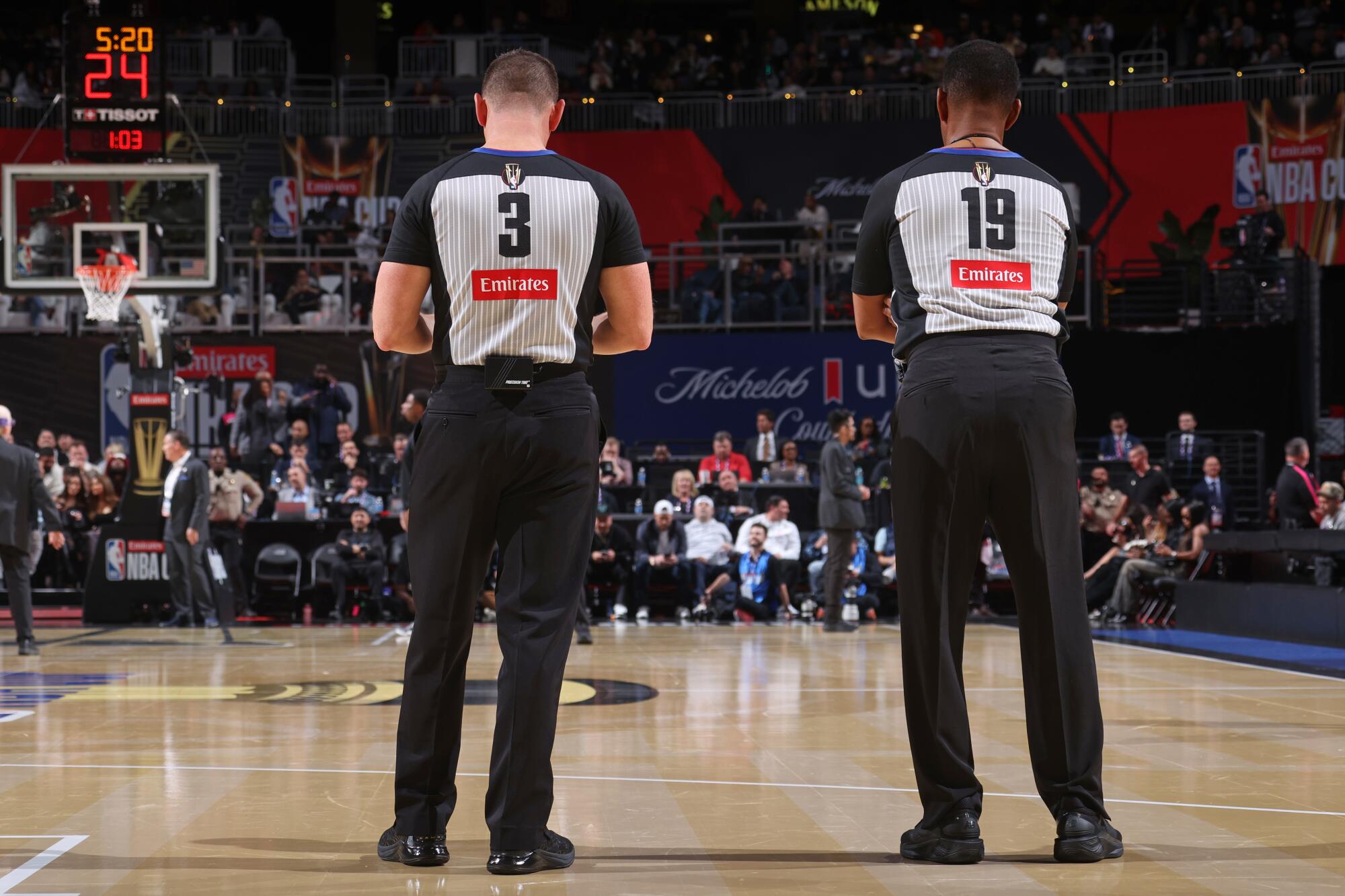 Two NBA officials stand on the court during a game between Houston and Oklahoma City.