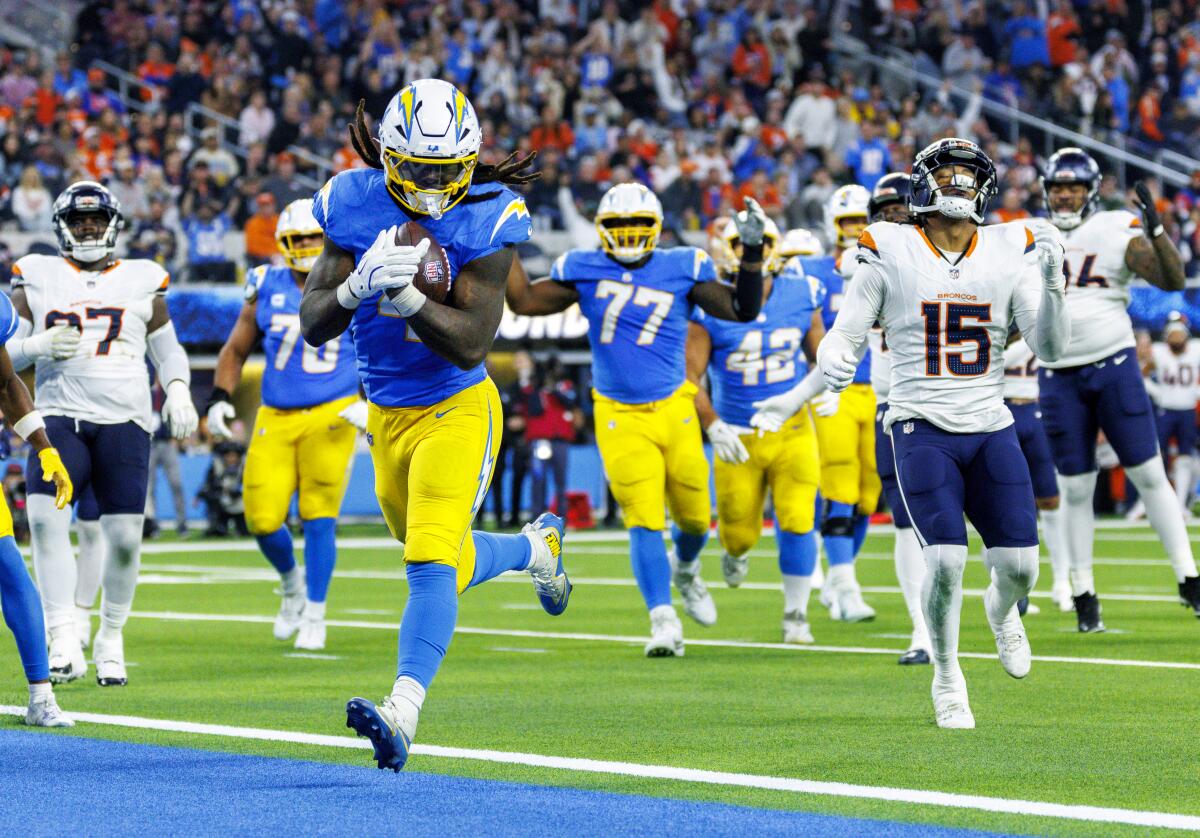 Chargers running back Gus Edwards (4) runs five yards for a third-quarter touchdown against the Broncos.