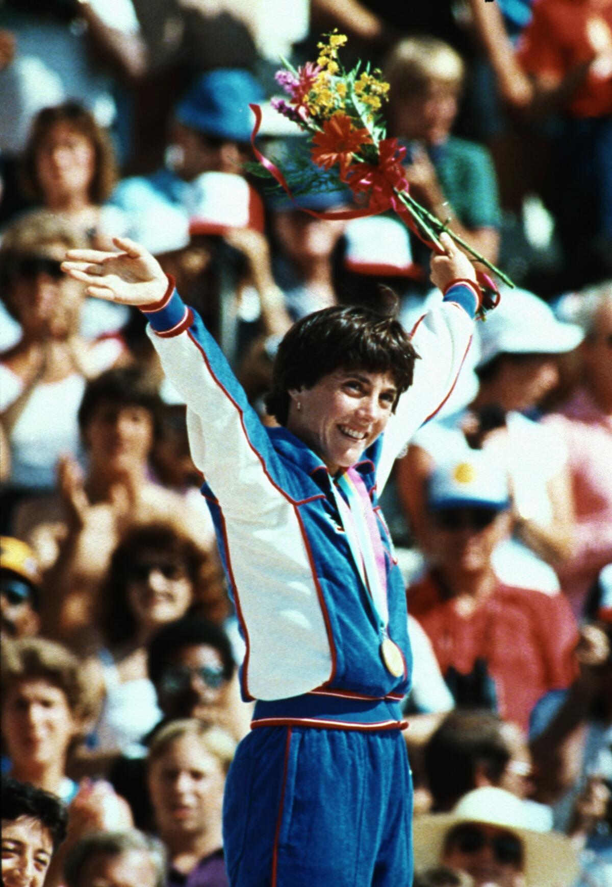 Joan Benoit celebrates on the top step of the podium after winning gold in the women's marathon.