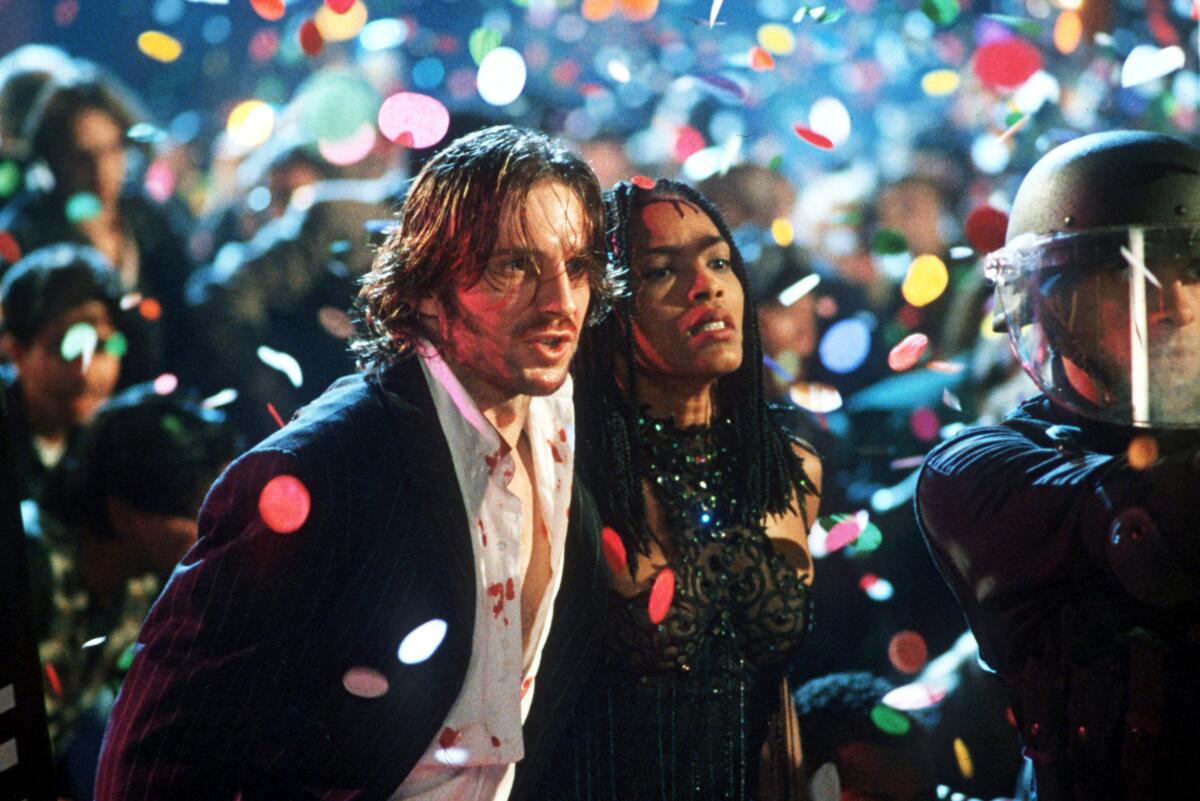 Two people run through a crowd on New Year's Eve.