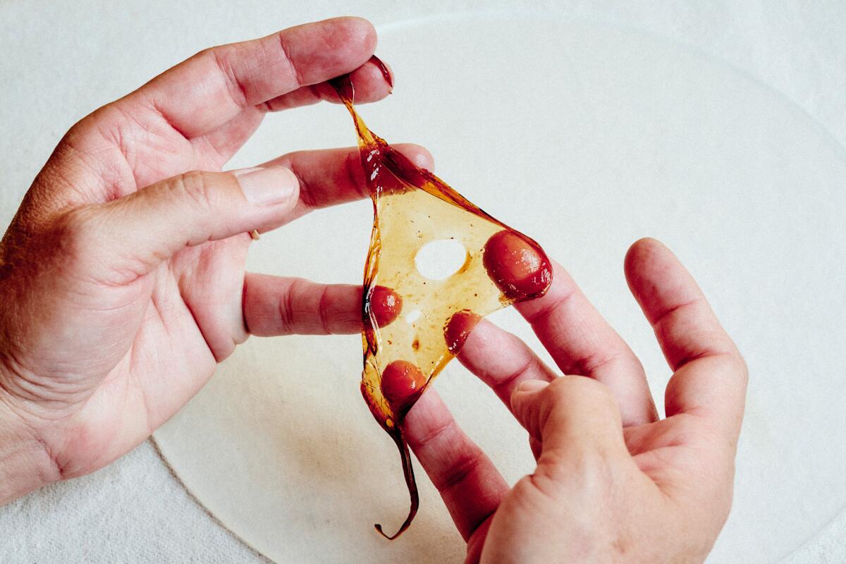 Two hands stretch a dehydrated film into a triangle