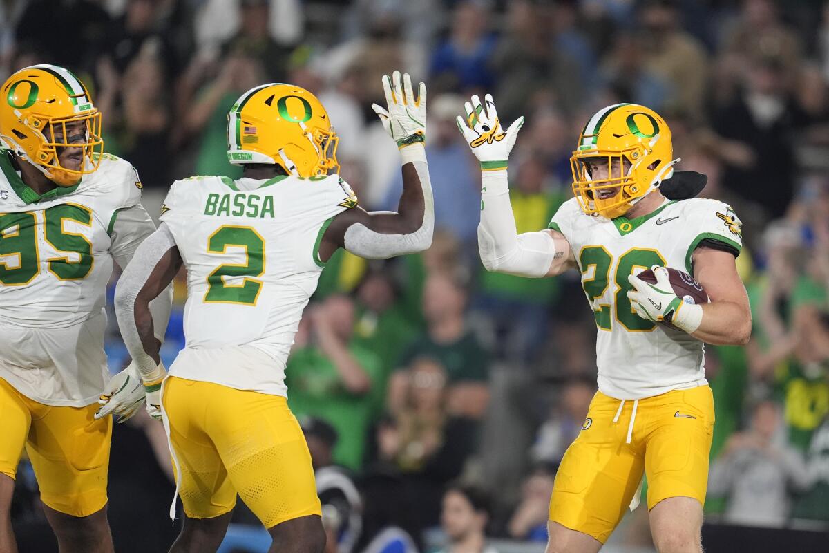 Oregon linebacker Bryce Boettcher celebrates with linebacker Jeffrey Bassa after intercepting a pass against UCLA 