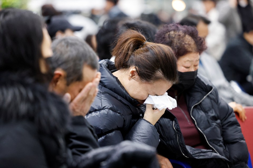 Relatives of passengers weep as they wait for news on their loved ones