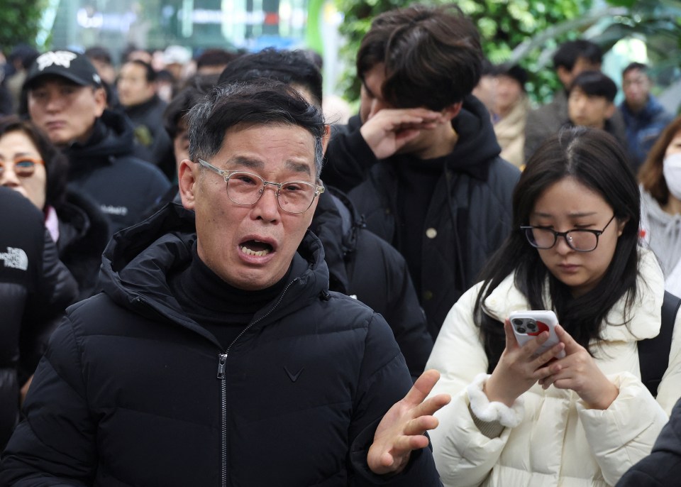 A relative of a passenger cries following the crash