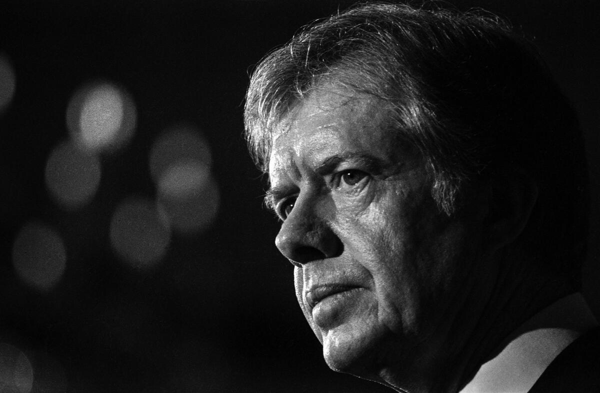 Former President Carter in profile as he delivers a speech.