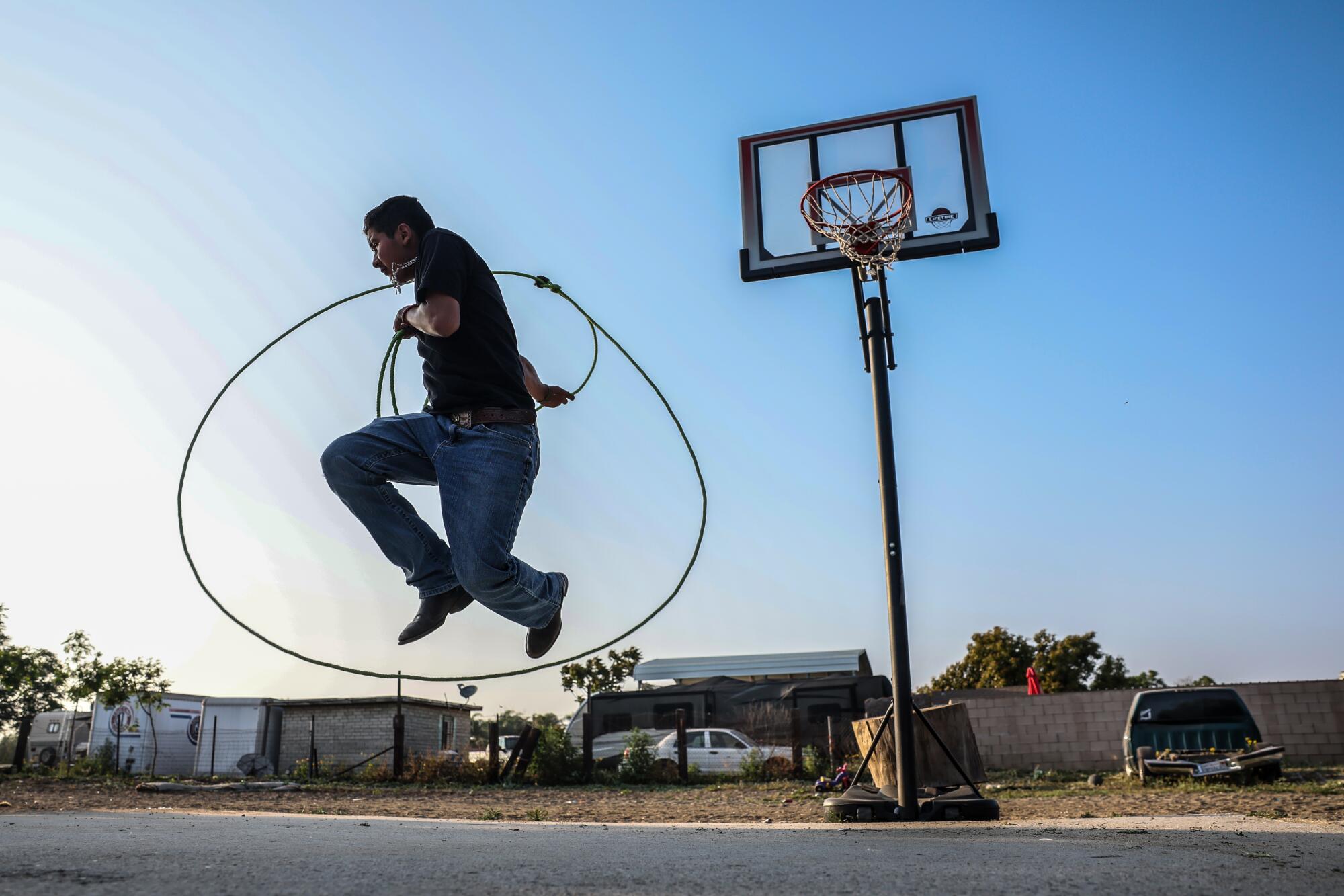 Jessie Ortiz practices his roping skills in the backyard.