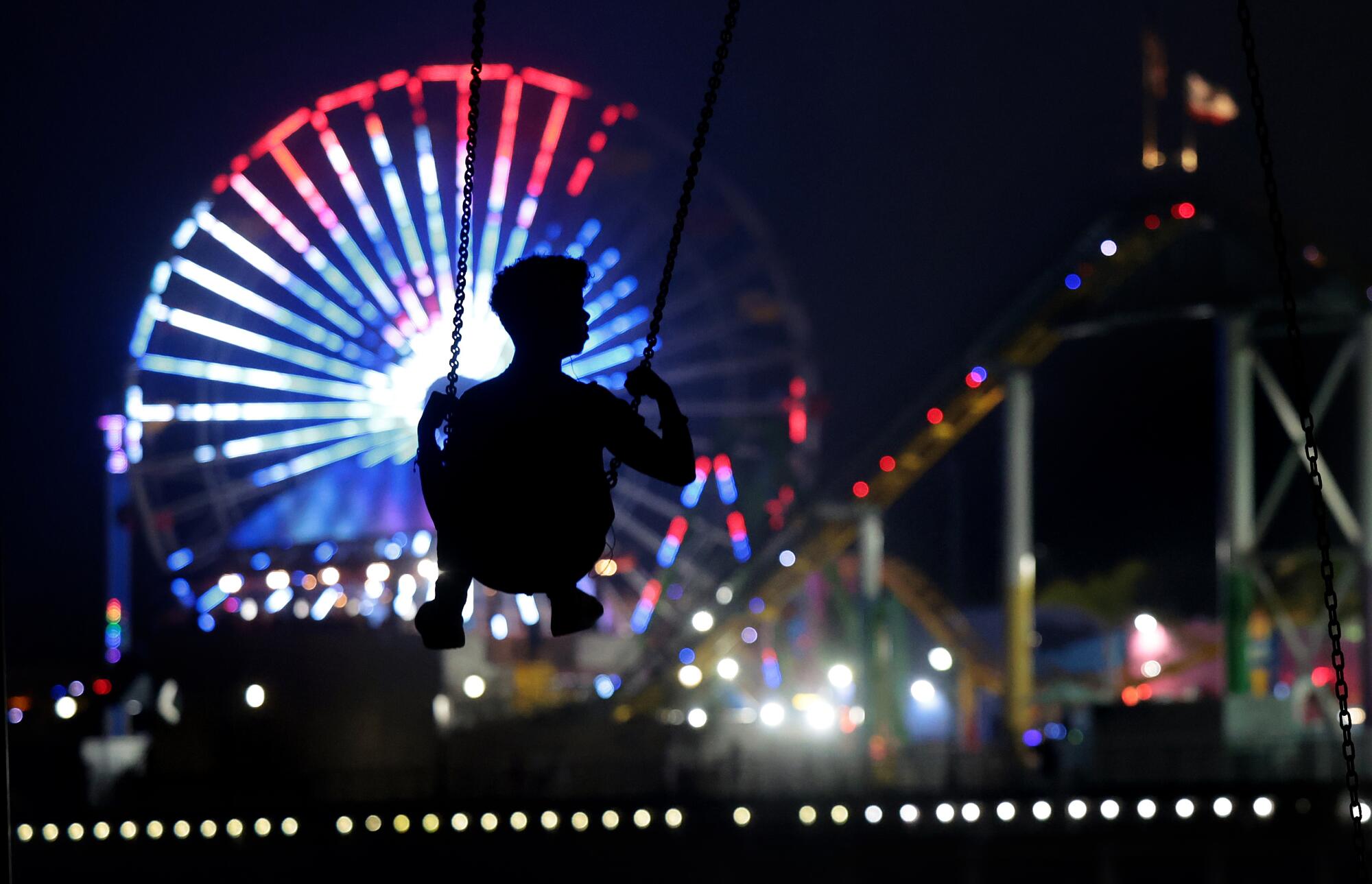 The Pacific Park Ferris wheel at the Santa Monica Pier is illuminated with red, white and blue.