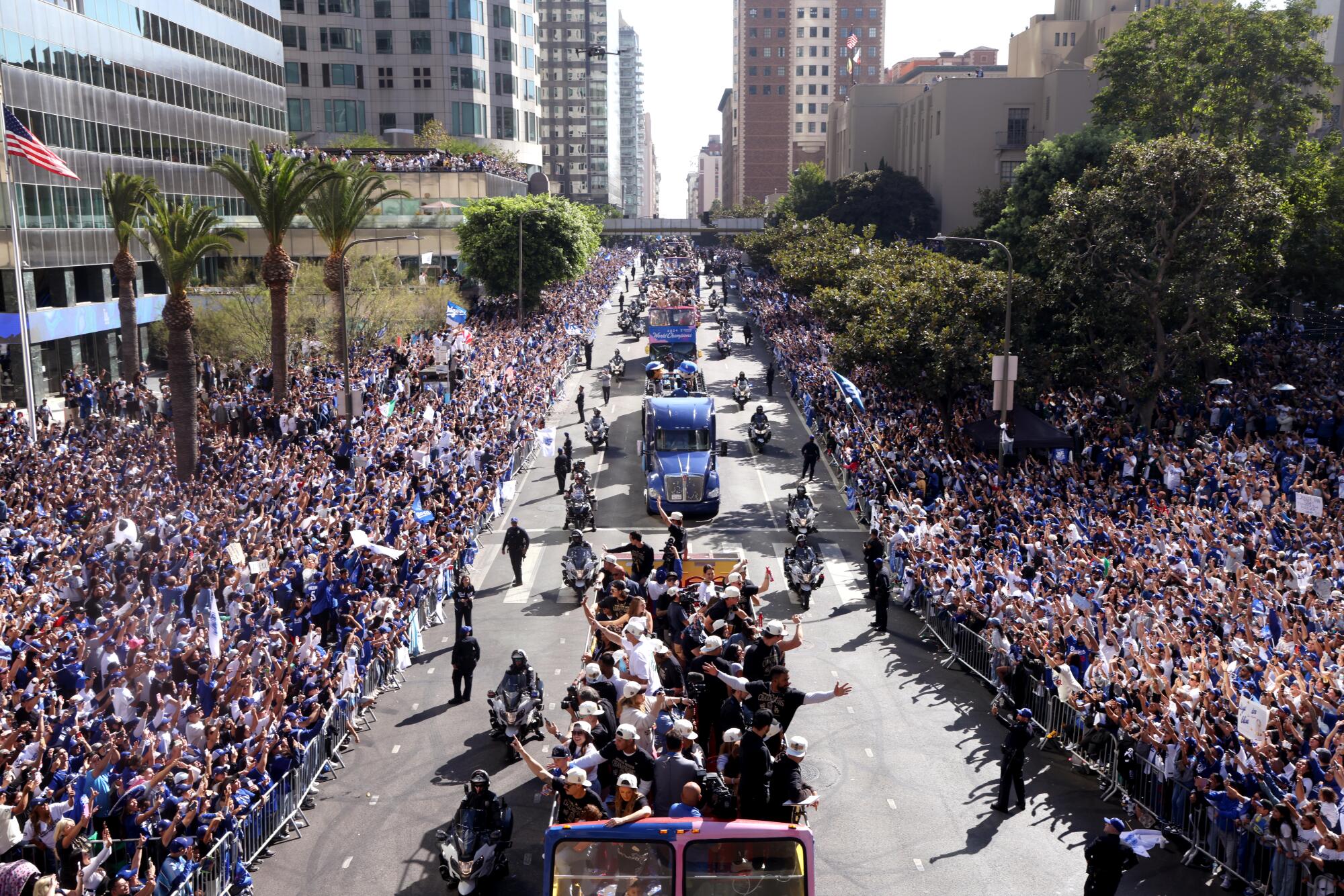 Los Angeles Dodgers celebrate their World Series win traveling in a parade along 5th Street in double-decker buses.