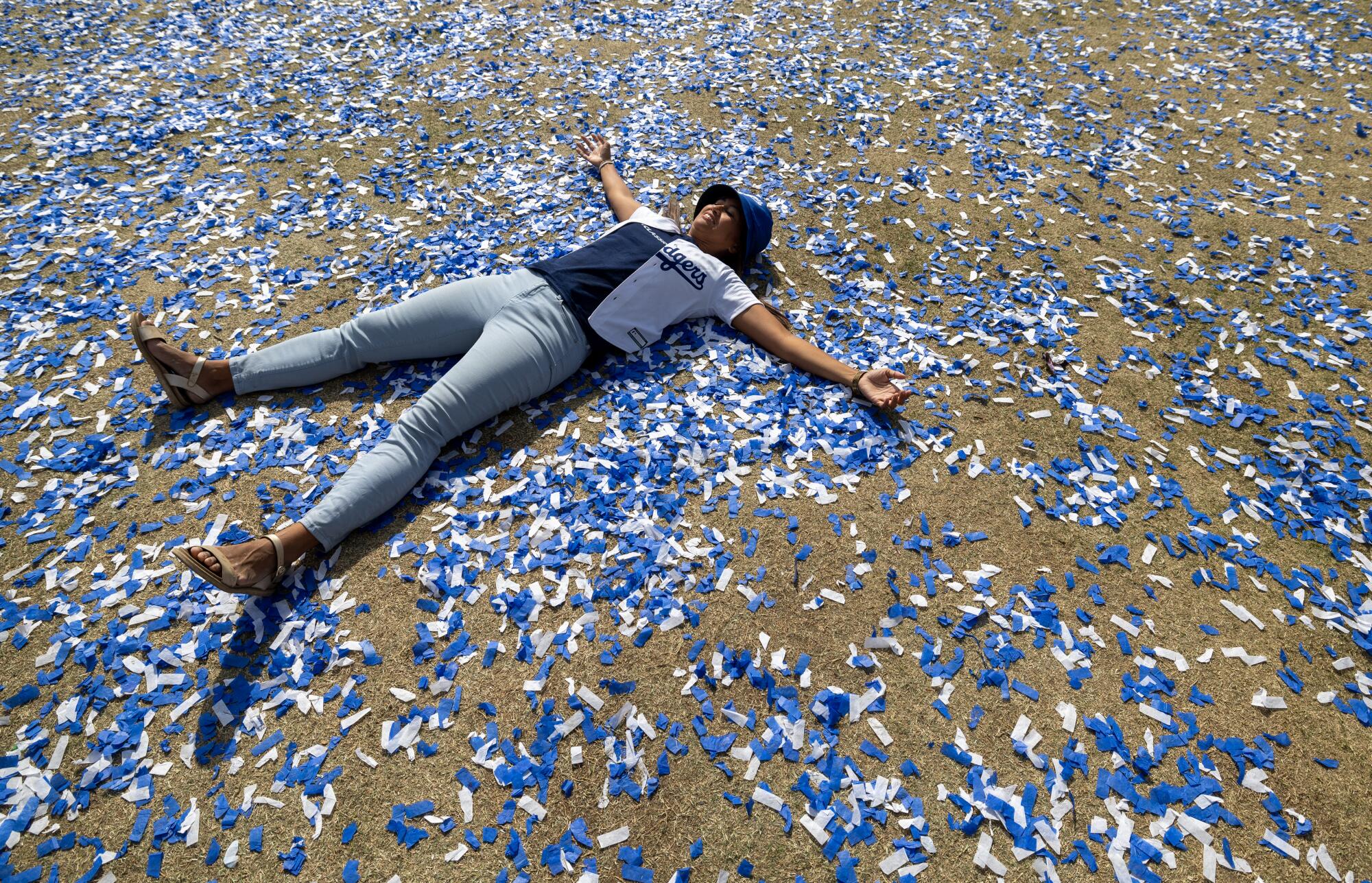 Dodgers fan Jenna Fuentes makes an angel in the confetti to celebrate the Dodgers World Series win.